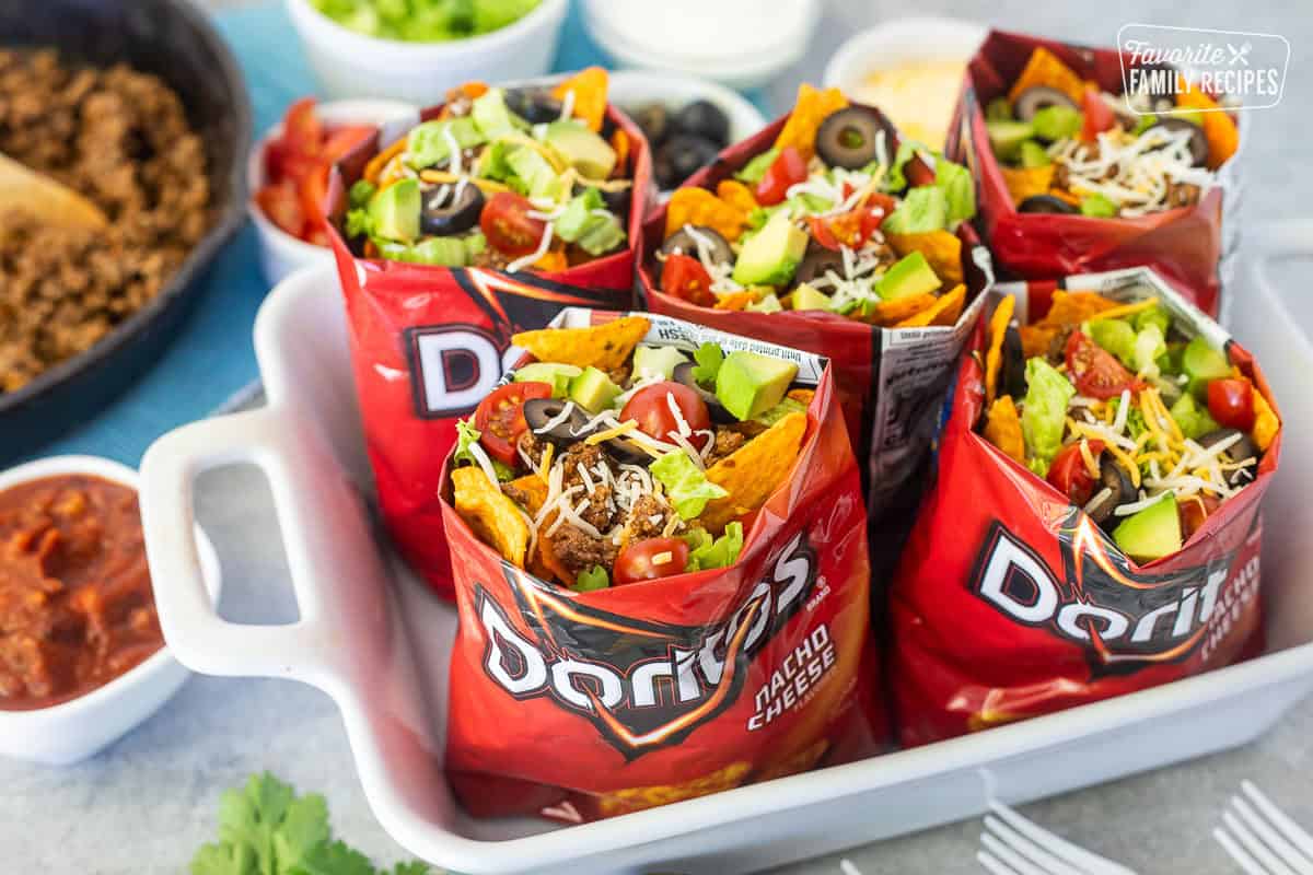 Bags of walking tacos with nacho cheese Doritos, seasoned ground beef, cheese, lettuce, tomatoes, olives and avocado.
