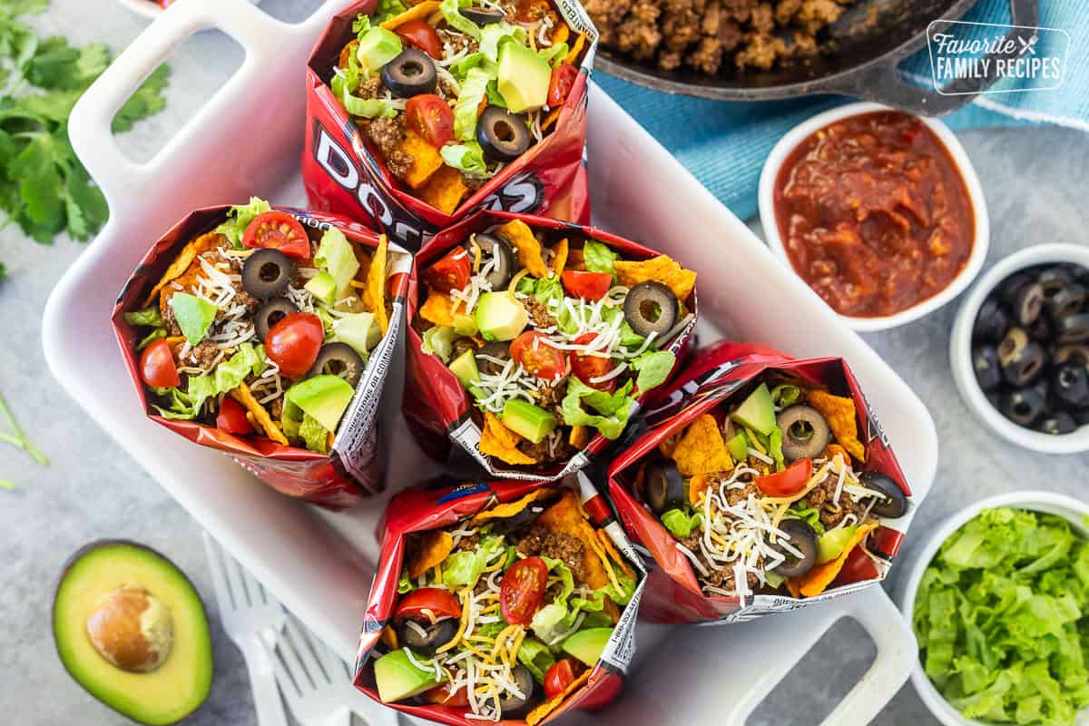 Bags of walking tacos with nacho cheese Doritos, seasoned ground beef, cheese, lettuce, tomatoes, olives and avocado.