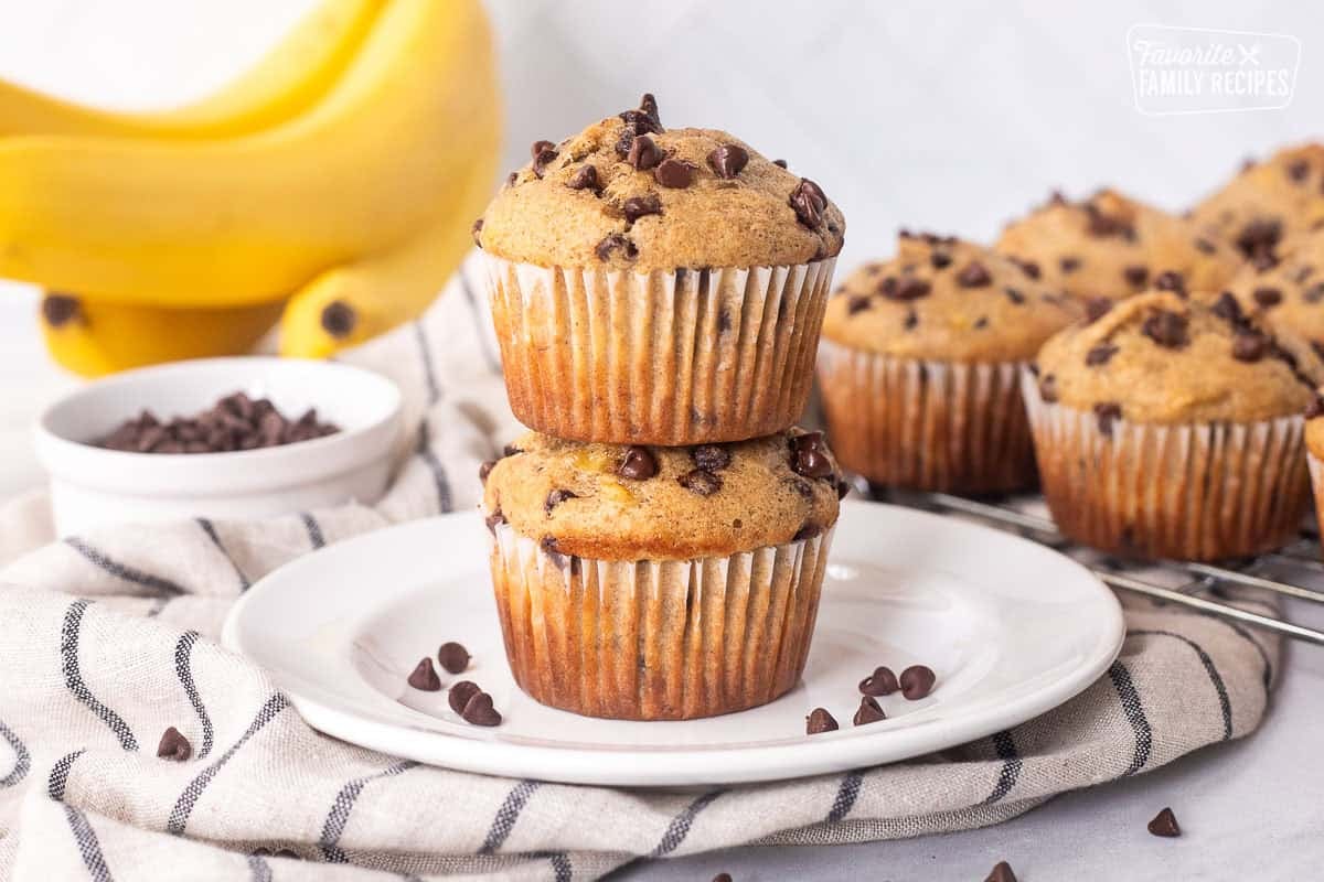 Two Banana Chocolate Chip muffins stacked on a plate.