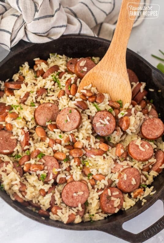 Skillet of Brazilian rice and beans with a wooden spoon.