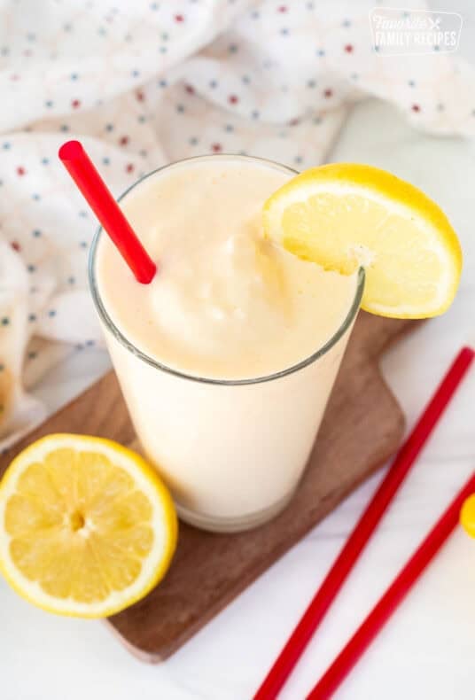 Chick Fil A Frosted Lemonade in a glass with a red straw and lemon slice on the side of the glass.