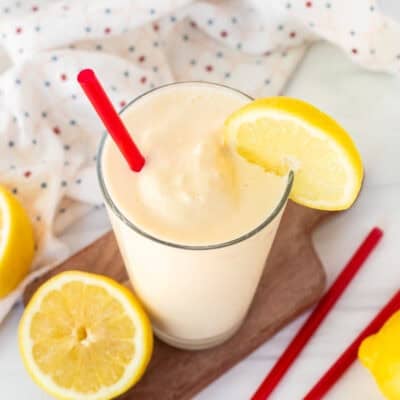 Chick Fil A Frosted Lemonade in a glass with a red straw and lemon slice on the side of the glass.