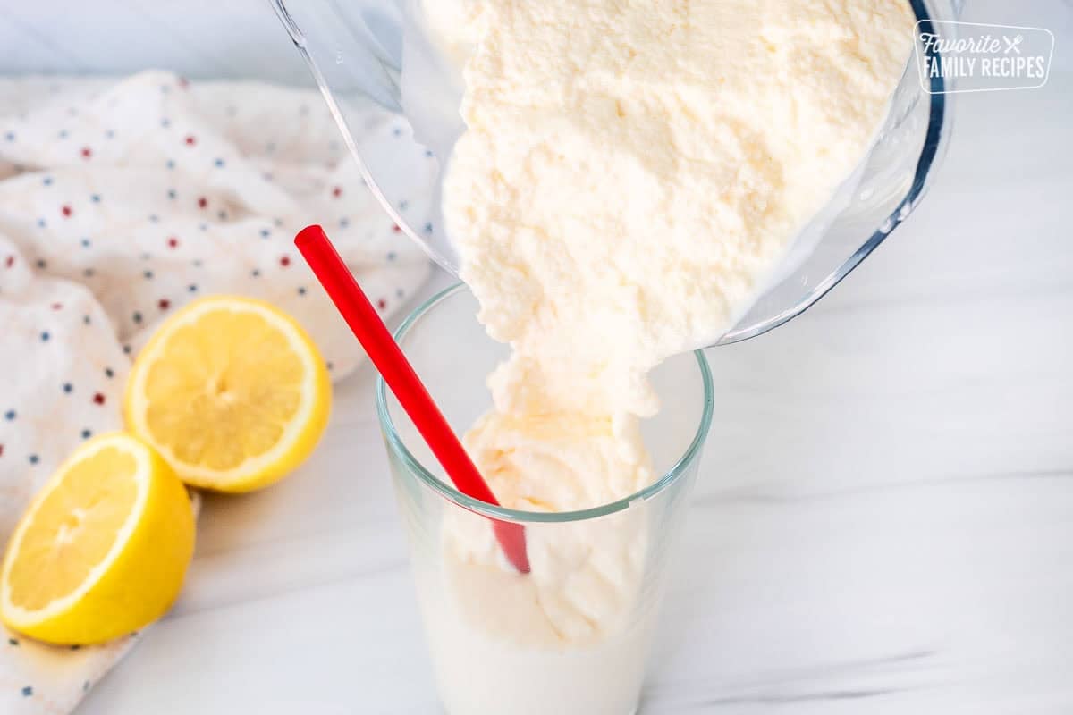 Pouring Chick Fil A Frosted Lemonade from blender into a glass with a red straw.