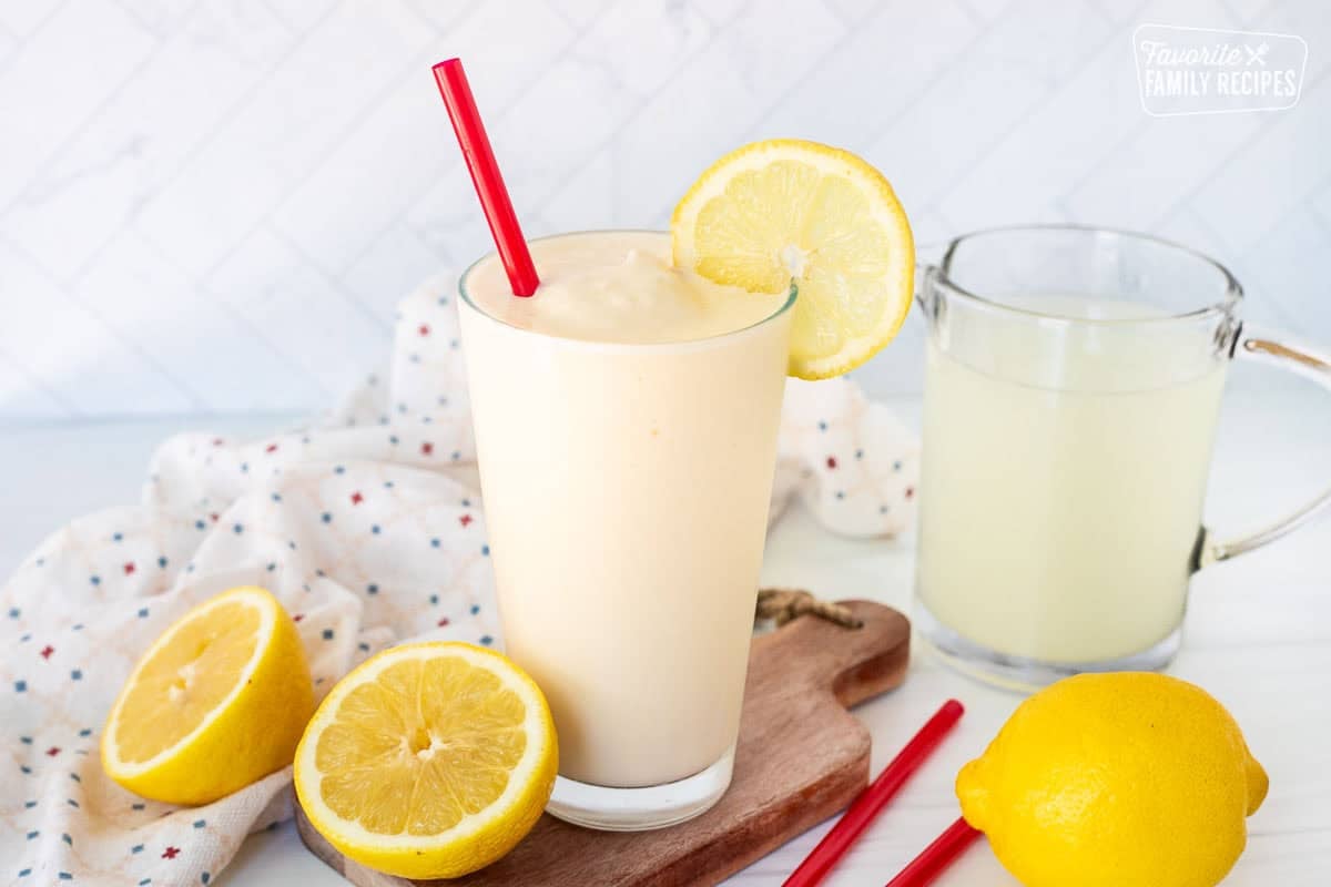 Glass of Chick Fil A Frosted Lemonade in a with a red straw and lemon slice on the rim of the glass.