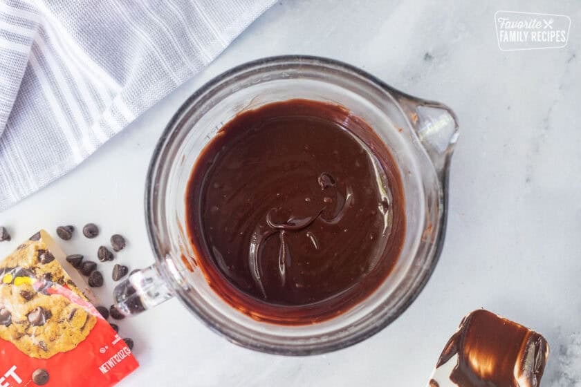Chocolate chips and heavy cream combined in a mixing bowl to make a chocolate ganache