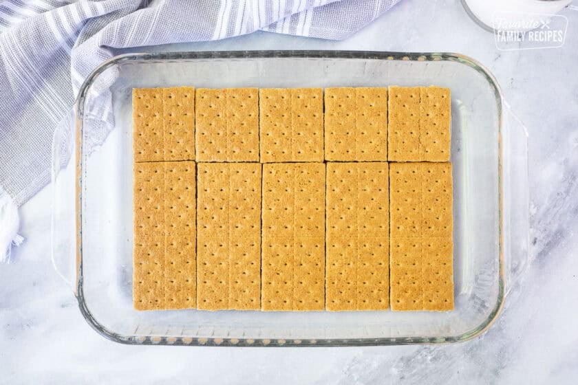 Graham crackers layered in the bottom of a baking dish to make an eclair cake