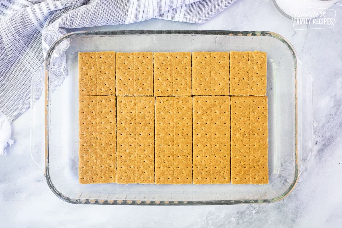 Graham crackers layered in the bottom of a baking dish to make an eclair cake