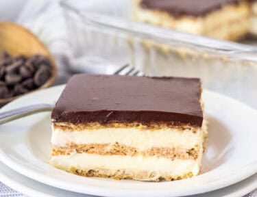 A slice of chocolate eclair cake double plated showing layers of the no bake dessert
