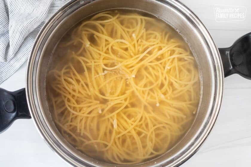 Large pot with cooked spaghetti and water.