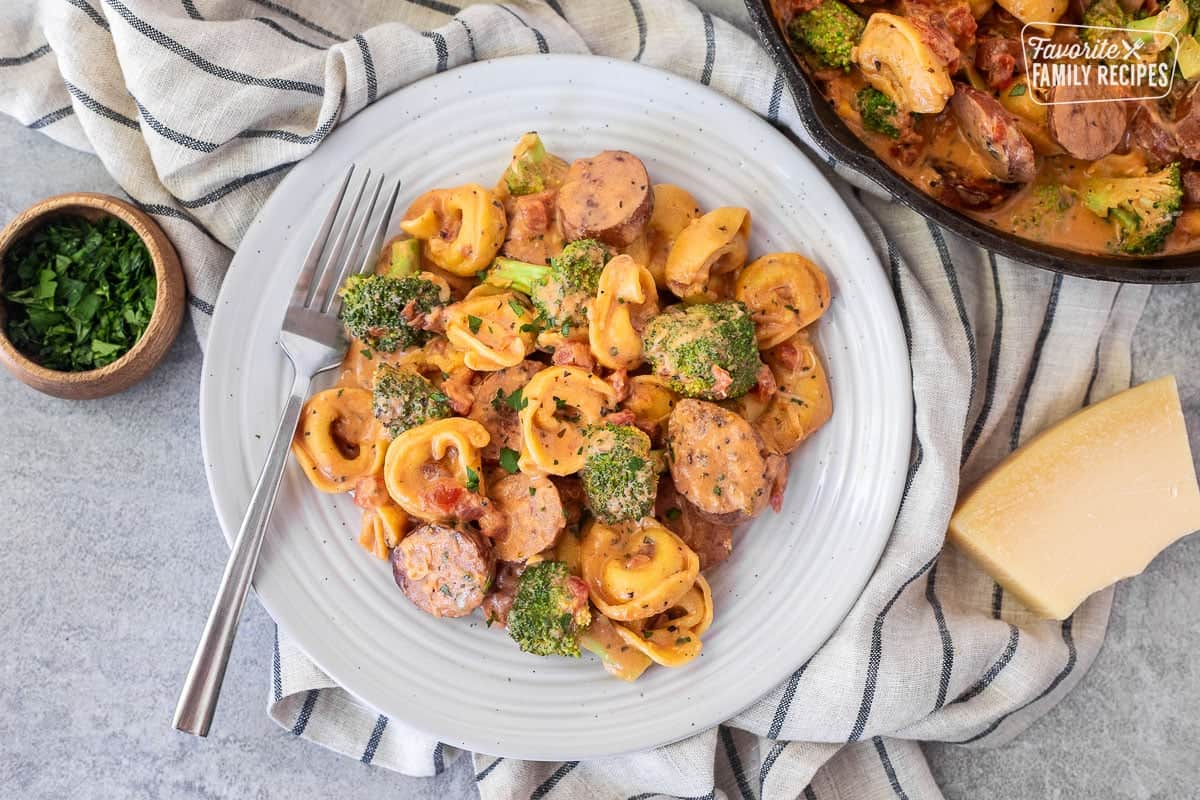 Plate with creamy one pot tortellini with sausage and broccoli.