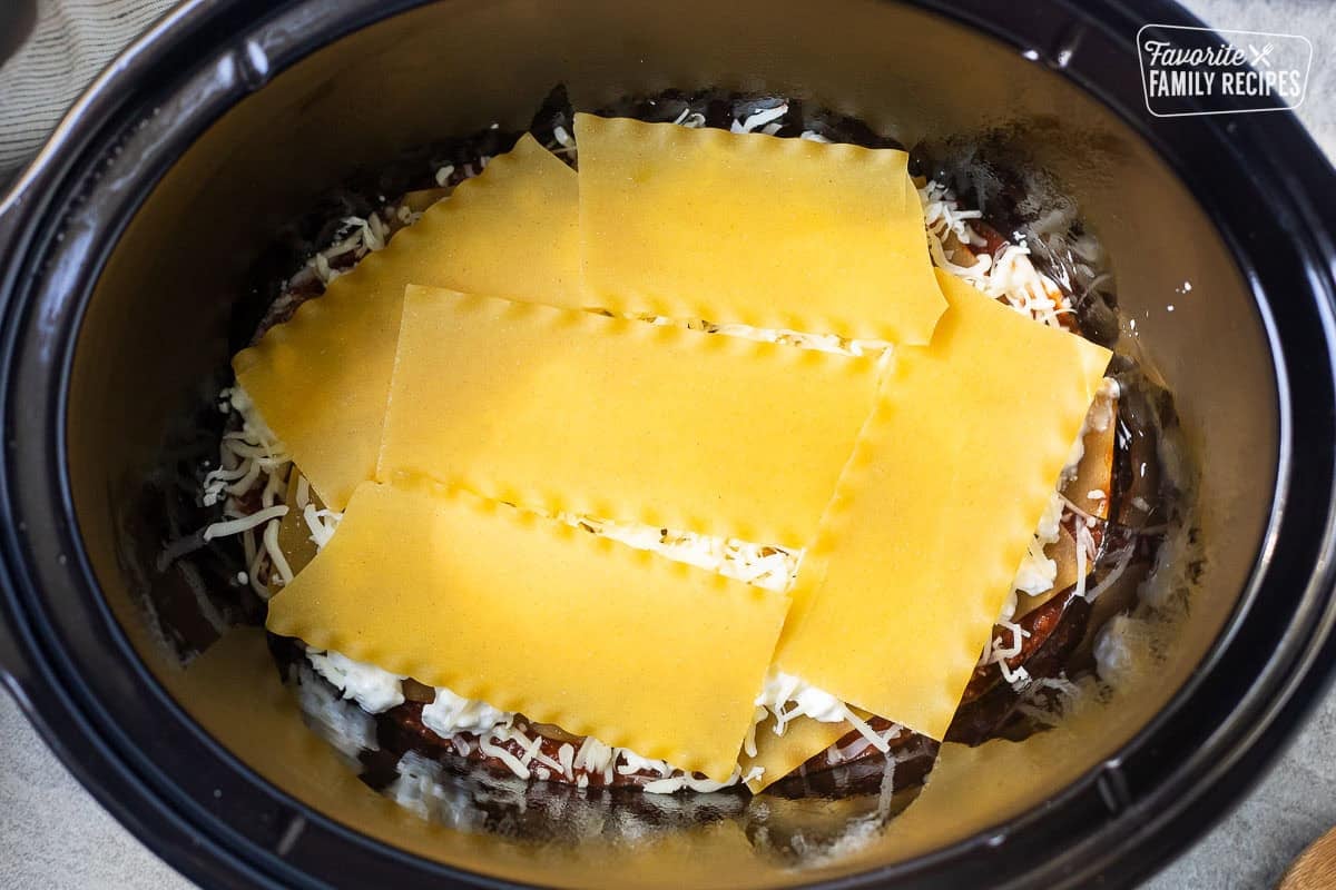 Crockpot with cut up noodles on top of first layer.