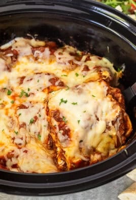 Lifting slice of crockpot lasagna with a spoon from the crockpot.
