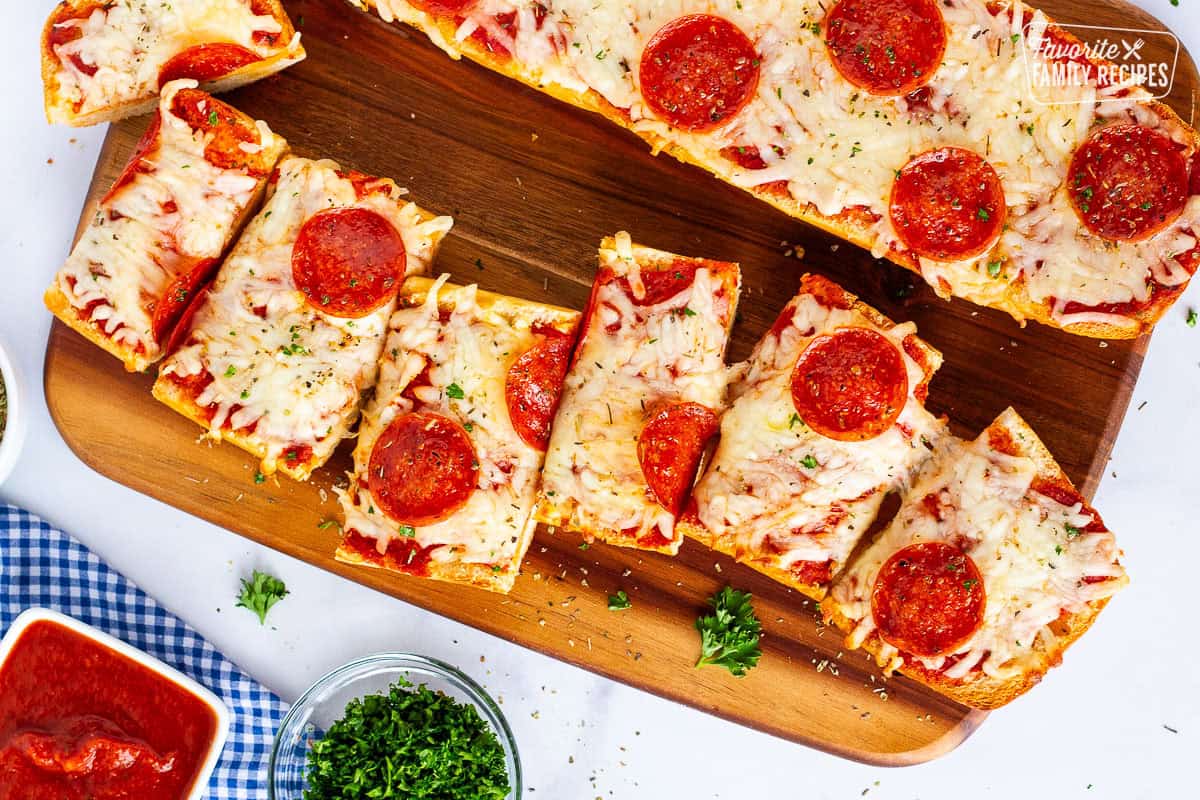 Sliced French bread pizza on a cutting board.