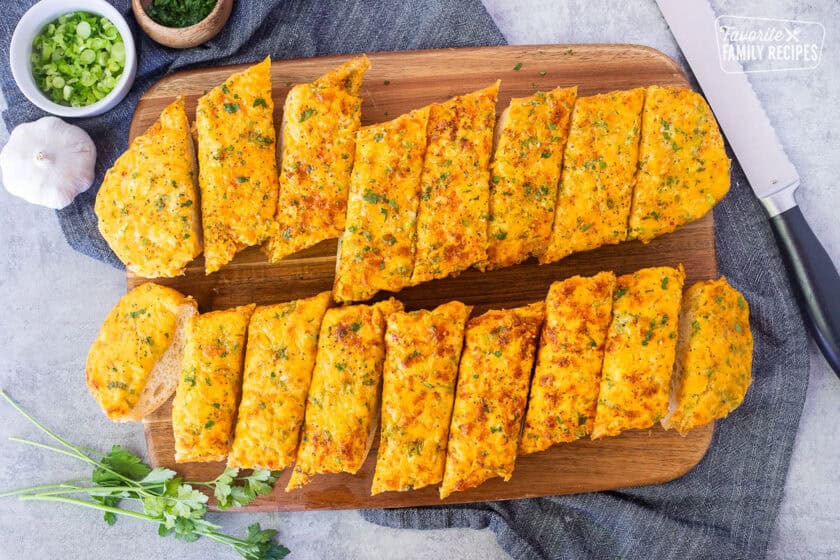 Cut French bread baked with garlic bread spread. Knife on the side.