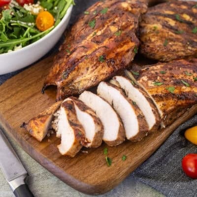 Sliced grilled balsamic chicken on a cutting board.