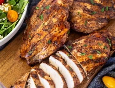 Sliced grilled balsamic chicken on a cutting board.