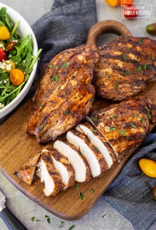 Sliced grilled balsamic chicken on a cutting board.