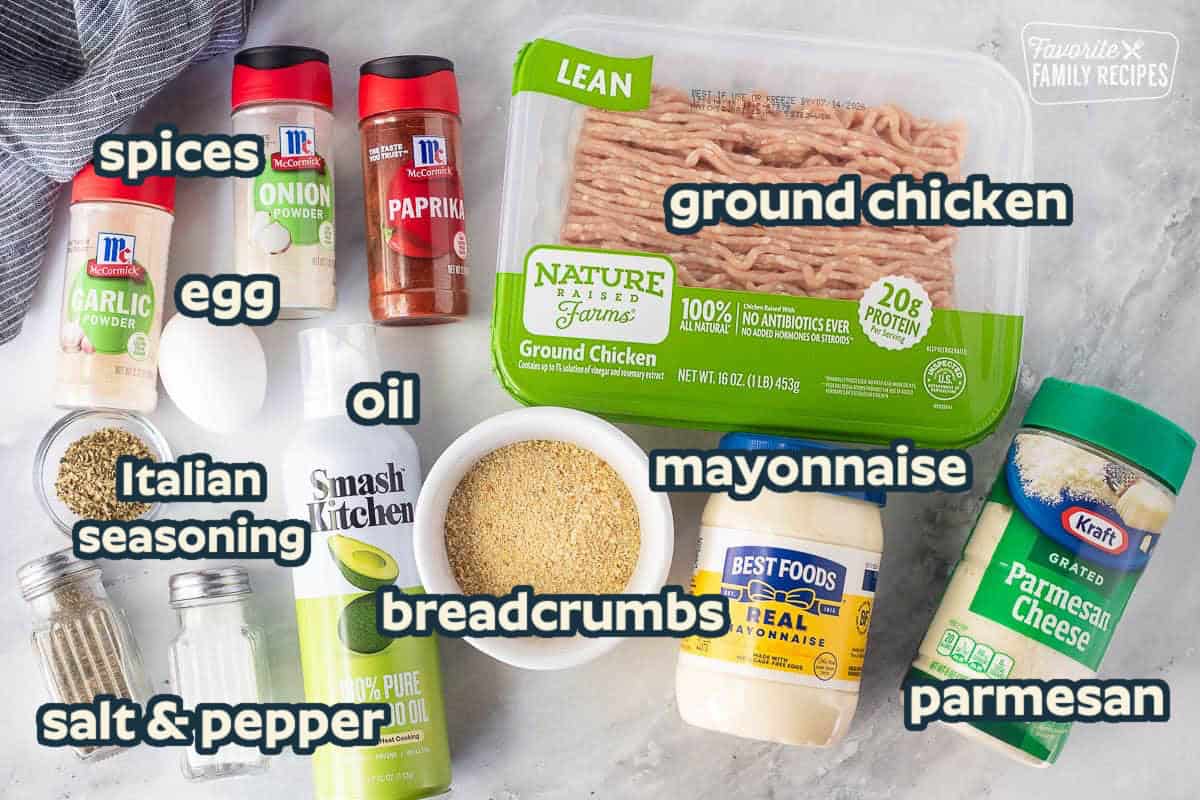 Ingredients to make ground chicken patties including ground chicken, parmesan cheese, mayonnaise, bread crumbs, avocado oil, salt, pepper, oregano, garlic powder, onion powder, paprika, and an egg.