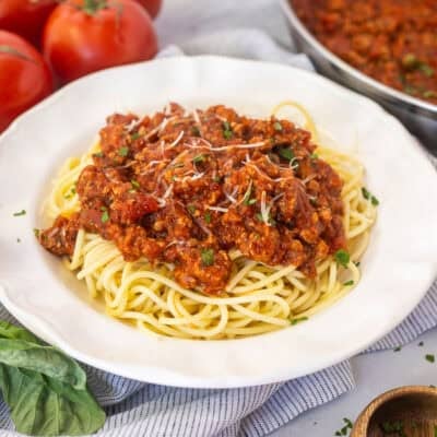 Ground turkey spaghetti on a plate with pasta topped with sauce.