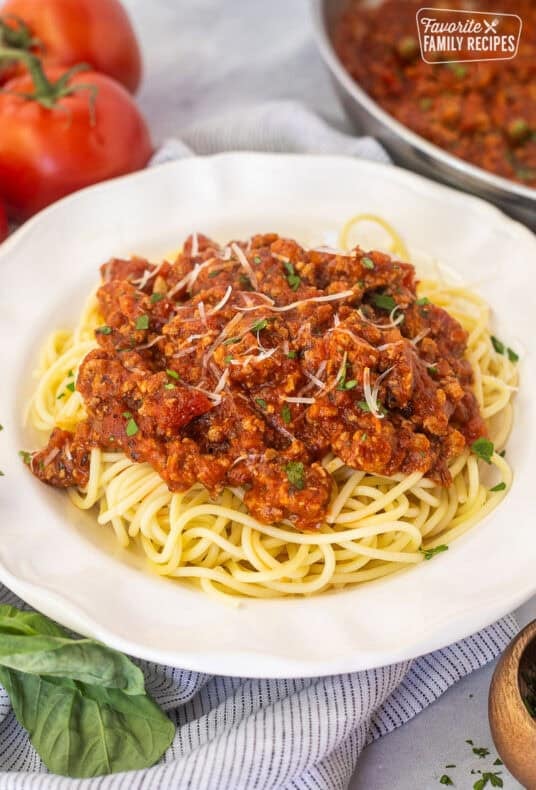 Ground turkey spaghetti on a plate with pasta topped with sauce.