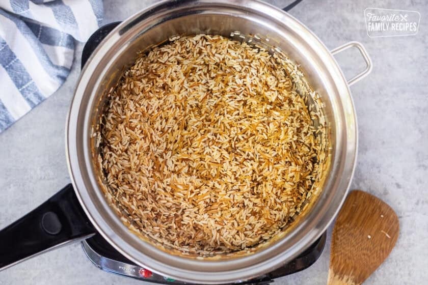 Saucepan with browned rice and vermicelli over electric skillet.