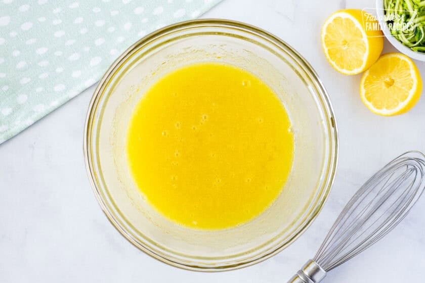 Glass mixing bowl with egg and oil mixed.