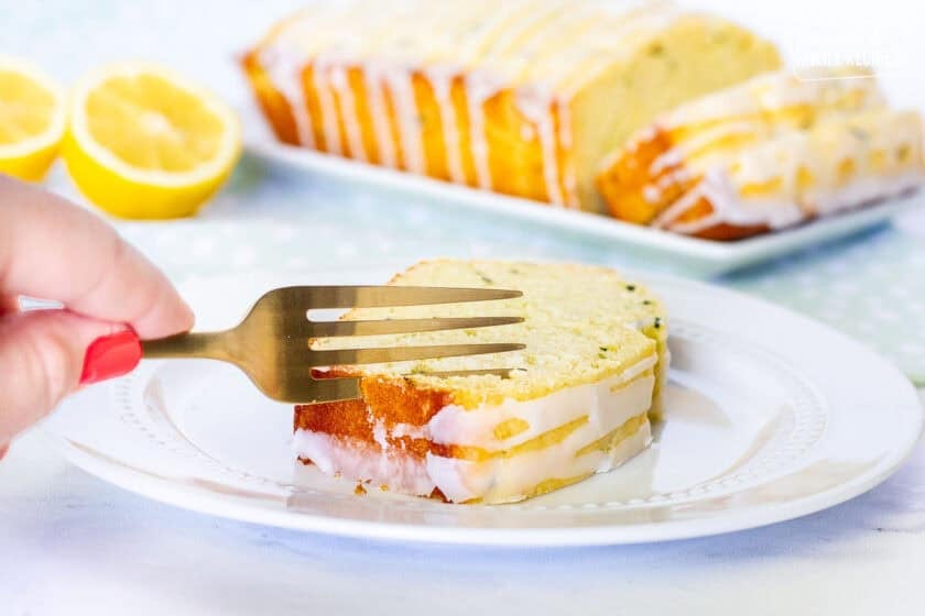 Cutting into a piece of lemon zucchini bread with a fork.
