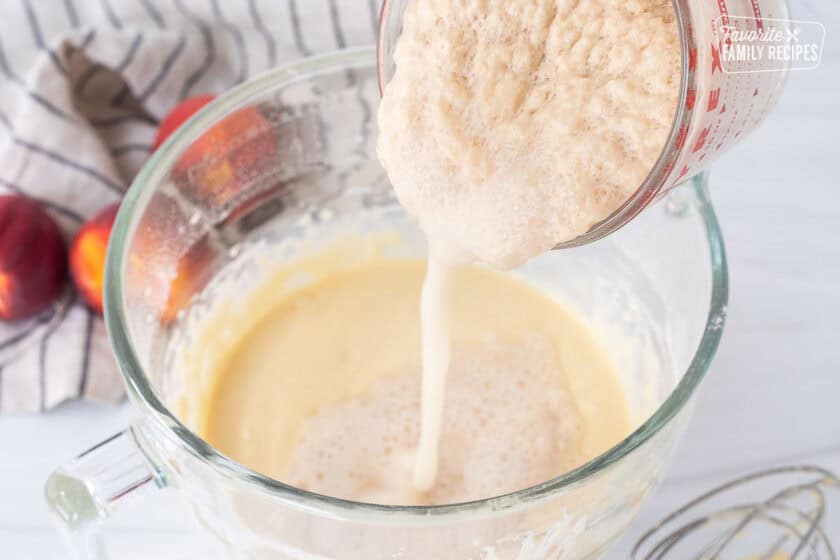 Pouring yeast mixture into glass mixing bowl.