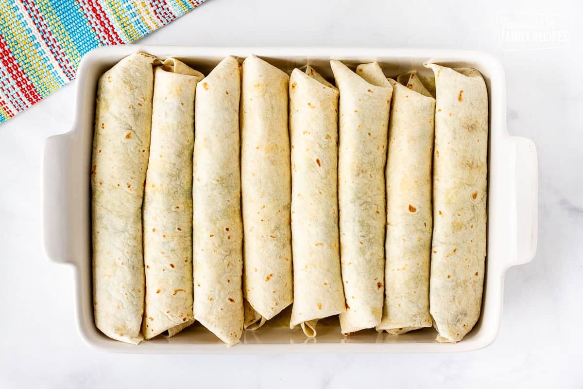 Baking dish with rolled spinach enchiladas.