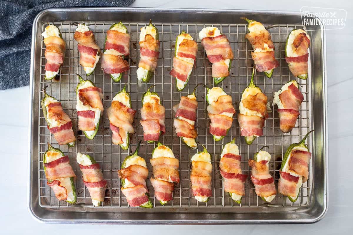 Baked bacon wrapped jalapeño poppers on a sheet pan.