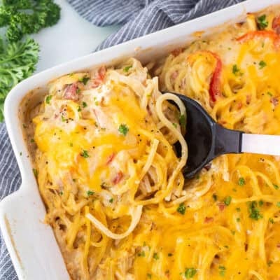 Spoon in casserole dish of chicken spaghetti casserole.