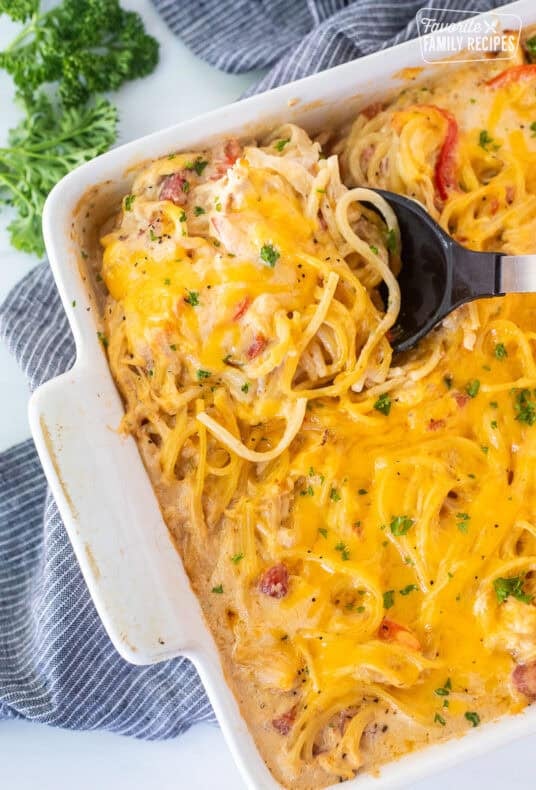 Spoon in casserole dish of chicken spaghetti casserole.