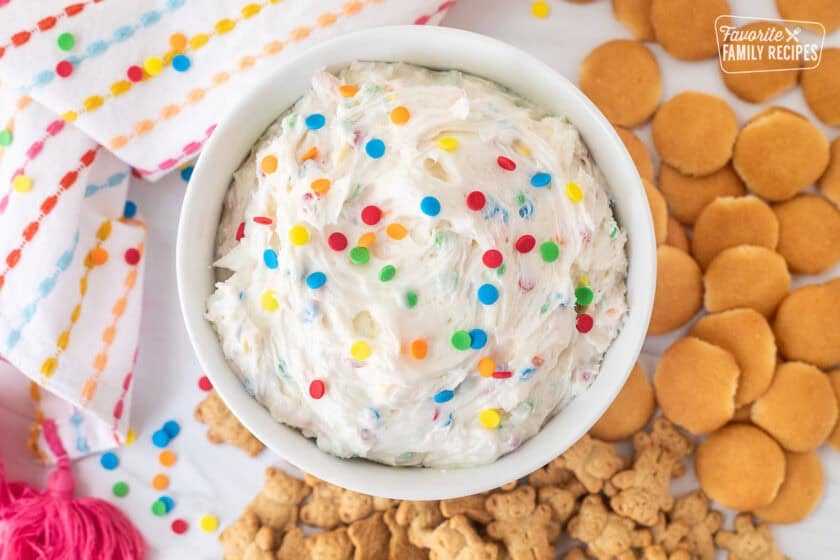 Dunkaroo dip in a bowl with extra sprinkles on top. Teddy grahams and mini Nilla wafers on the side.