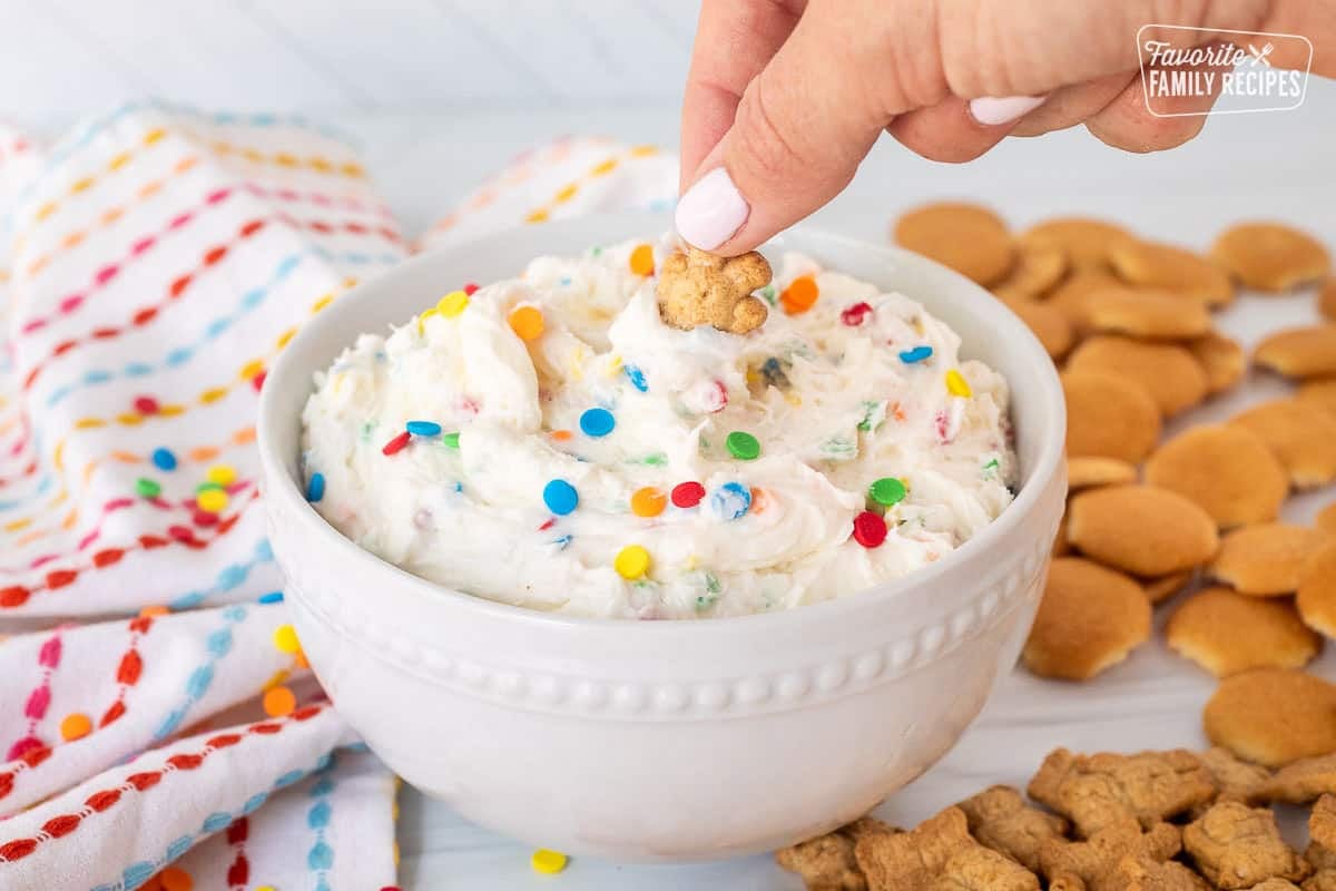 Dipping a teddy graham into a bowl of Dunkaroo dip.