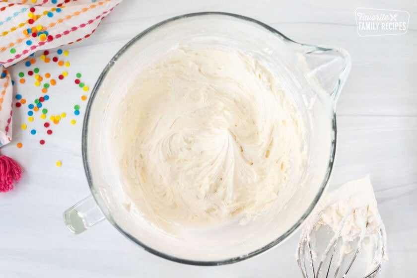 Glass mixing bowl with frosting and whisk attachment on the side.