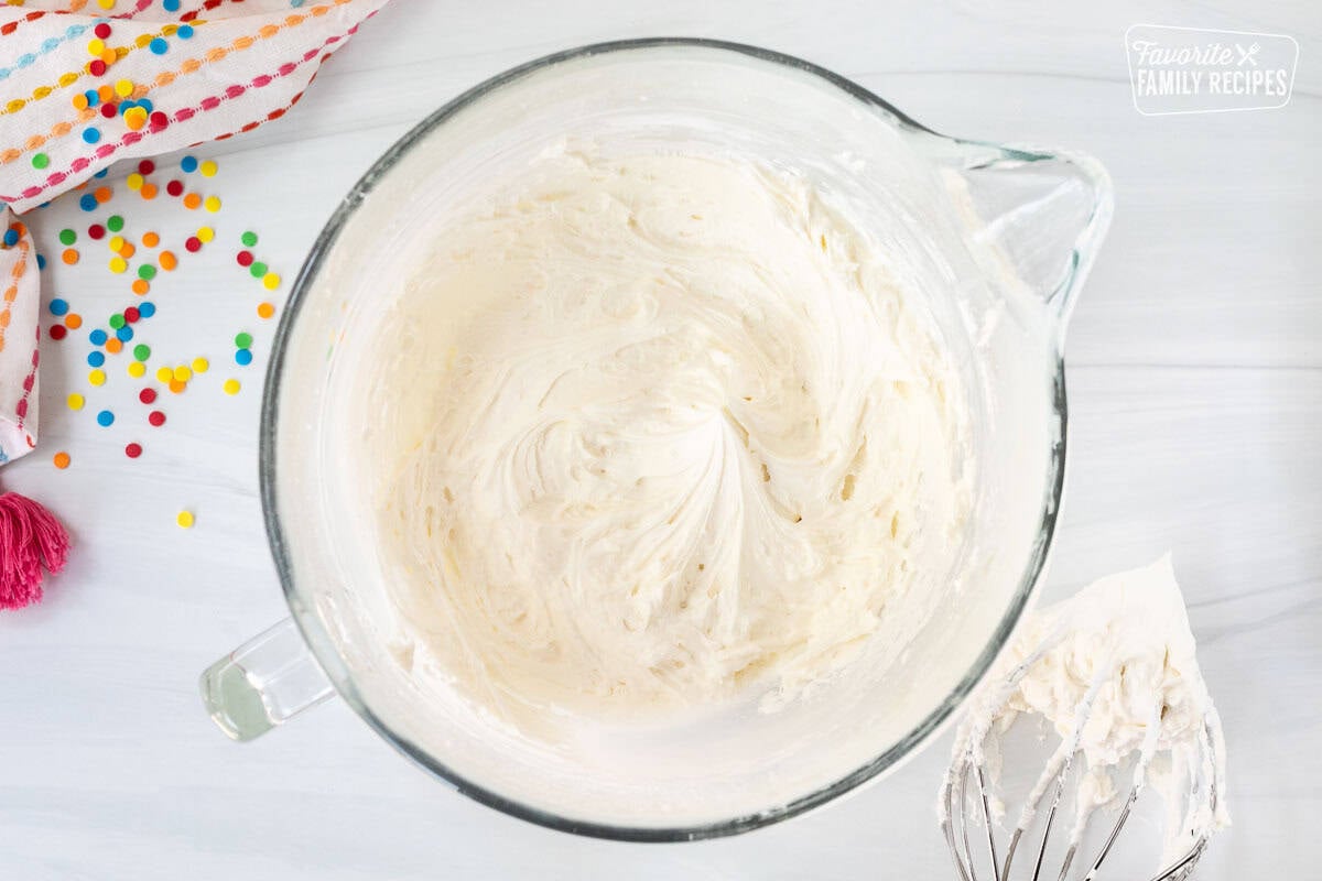 Glass mixing bowl with frosting and whisk attachment on the side.
