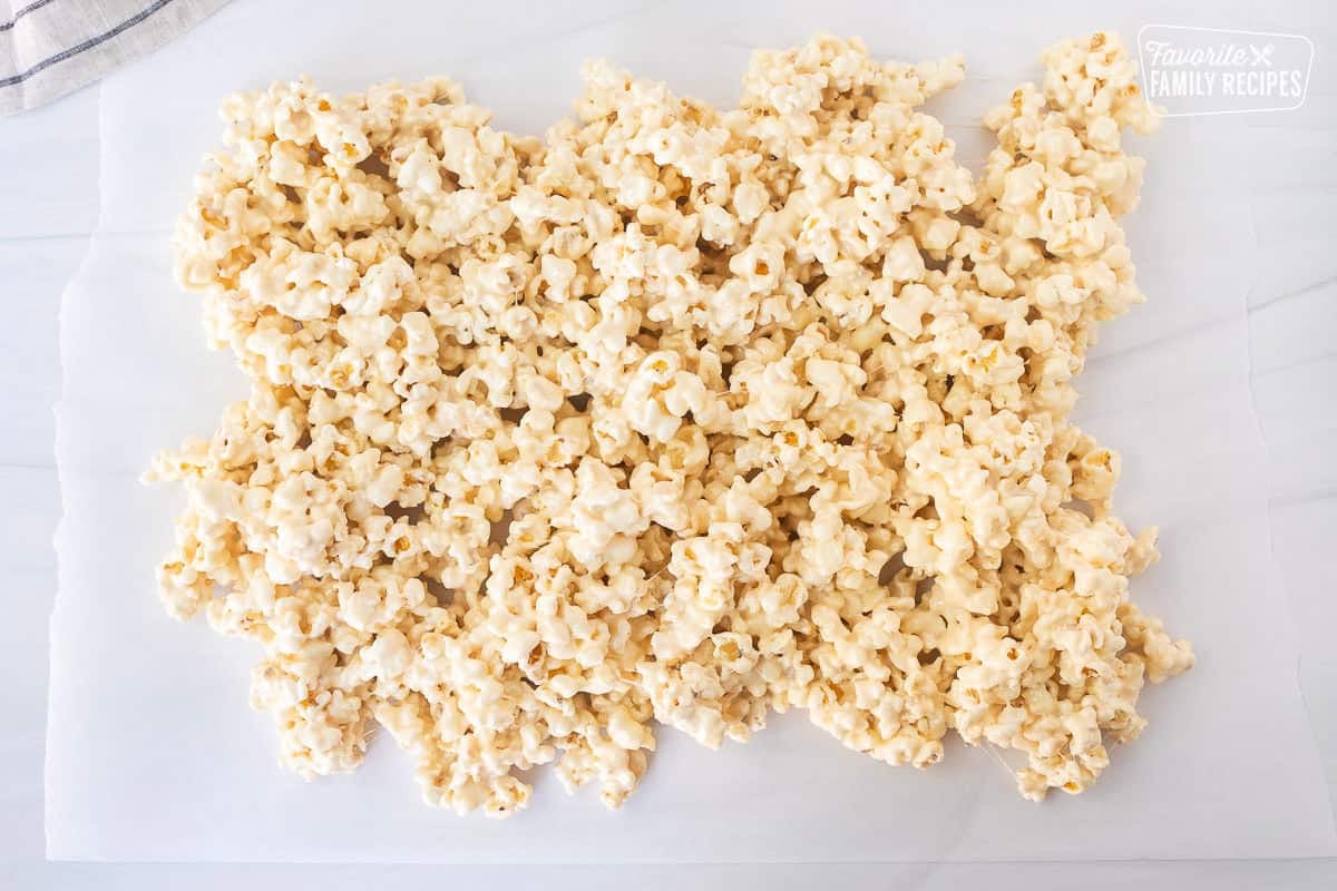 Marshmallow popcorn cooling on parchment paper.