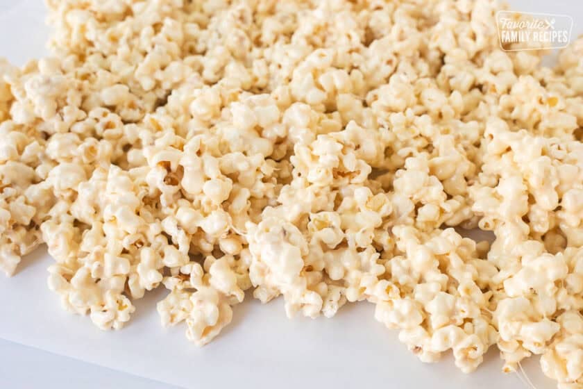 Marshmallow popcorn cooling on parchment paper.