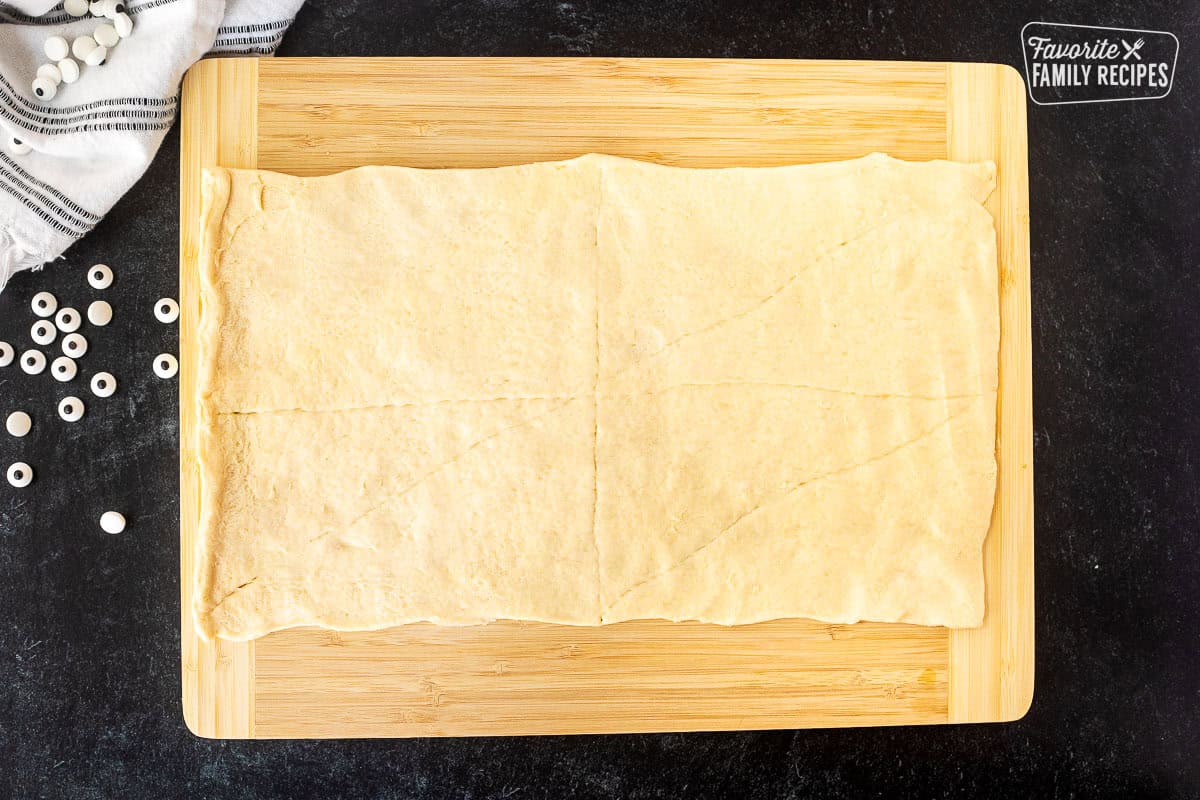 Smoothed out crescent roll sheet on a cutting board.