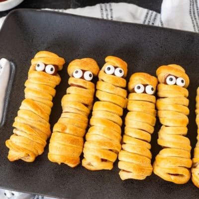 Mummy hot dogs lined in a row with candy eyeballs.