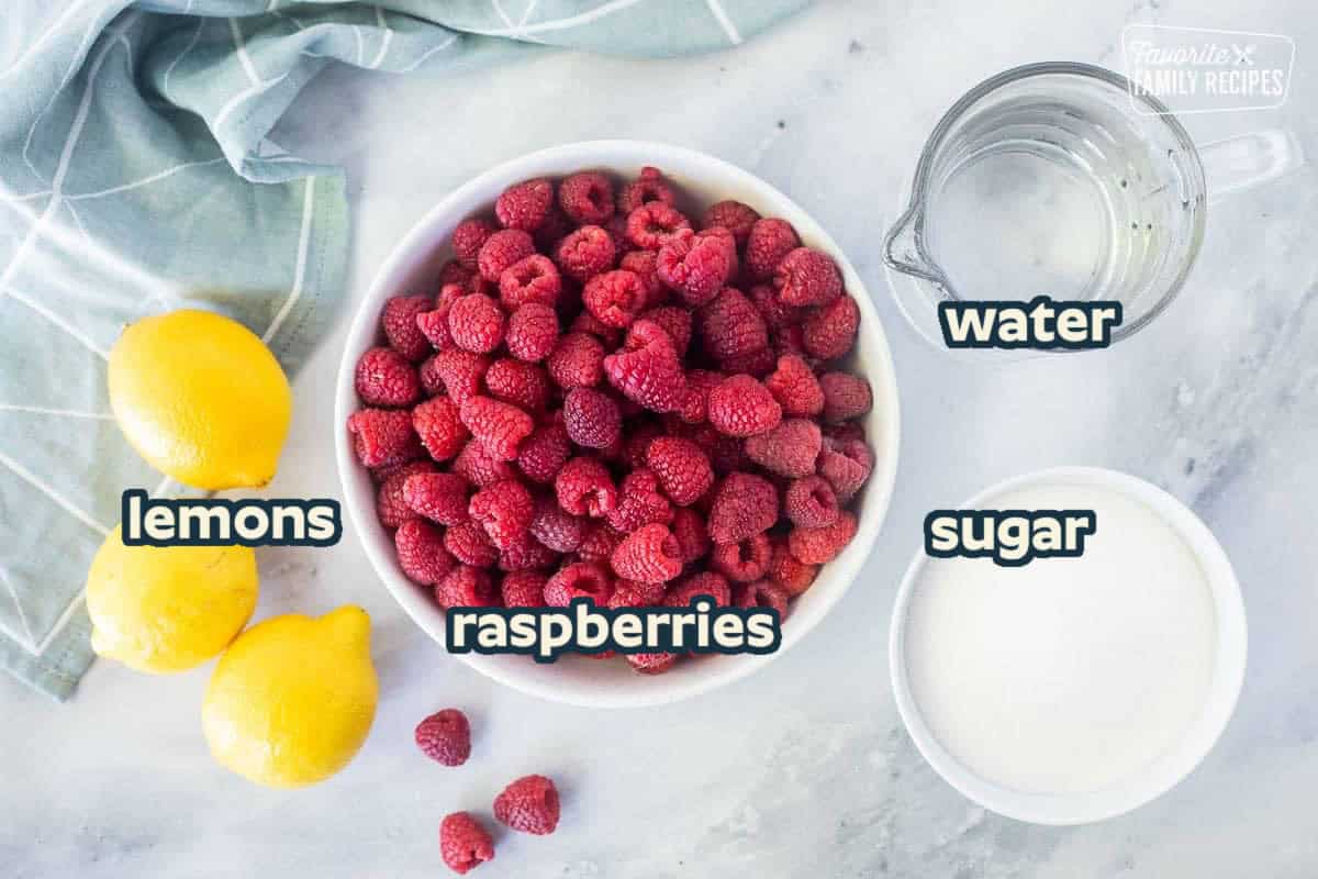 Ingredients to make raspberry cordial including fresh raspberries, water, sugar and lemons.