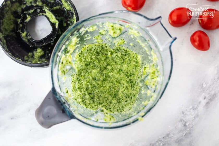 Blender with vegetables blended for savory canned salsa.