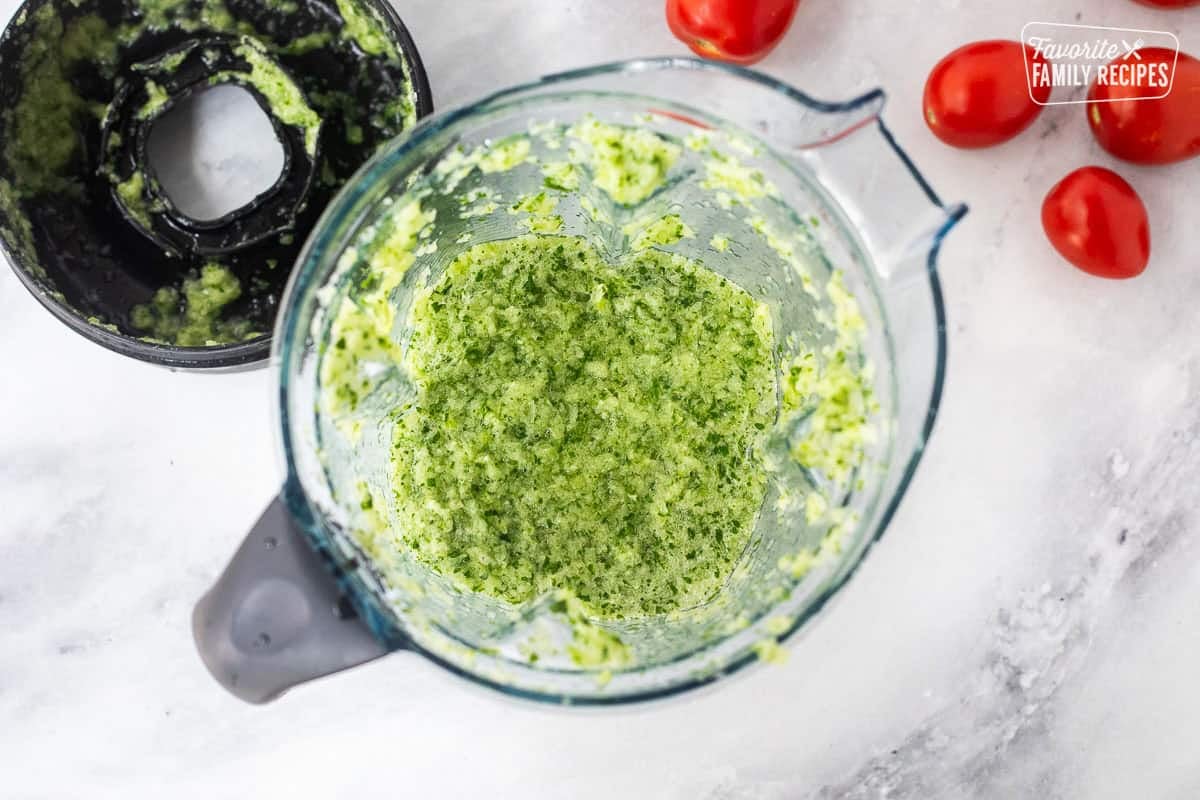 Blender with vegetables blended for savory canned salsa.
