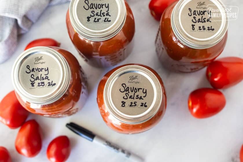 Savory salsa written on top of canning jar lids with Sharpie.