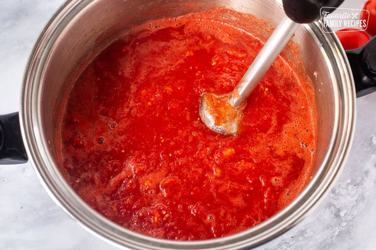 Using immersion blender with cooked down tomatoes.