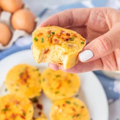 Holding Starbucks egg bite in hand with a bite taken out of it.