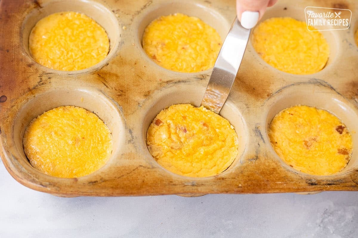 Scraping around sides of Starbucks egg bites with a knife.