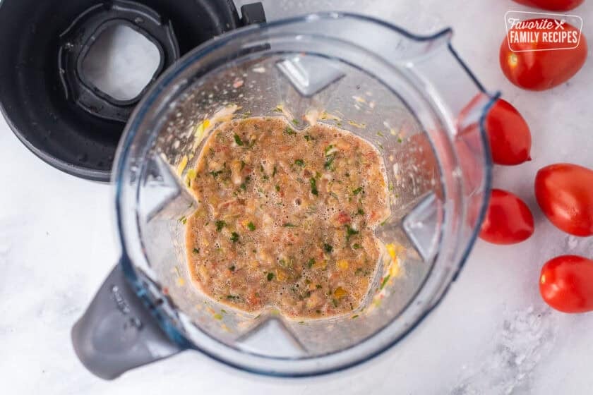Blender with vegetables blended together for sweet canned salsa.