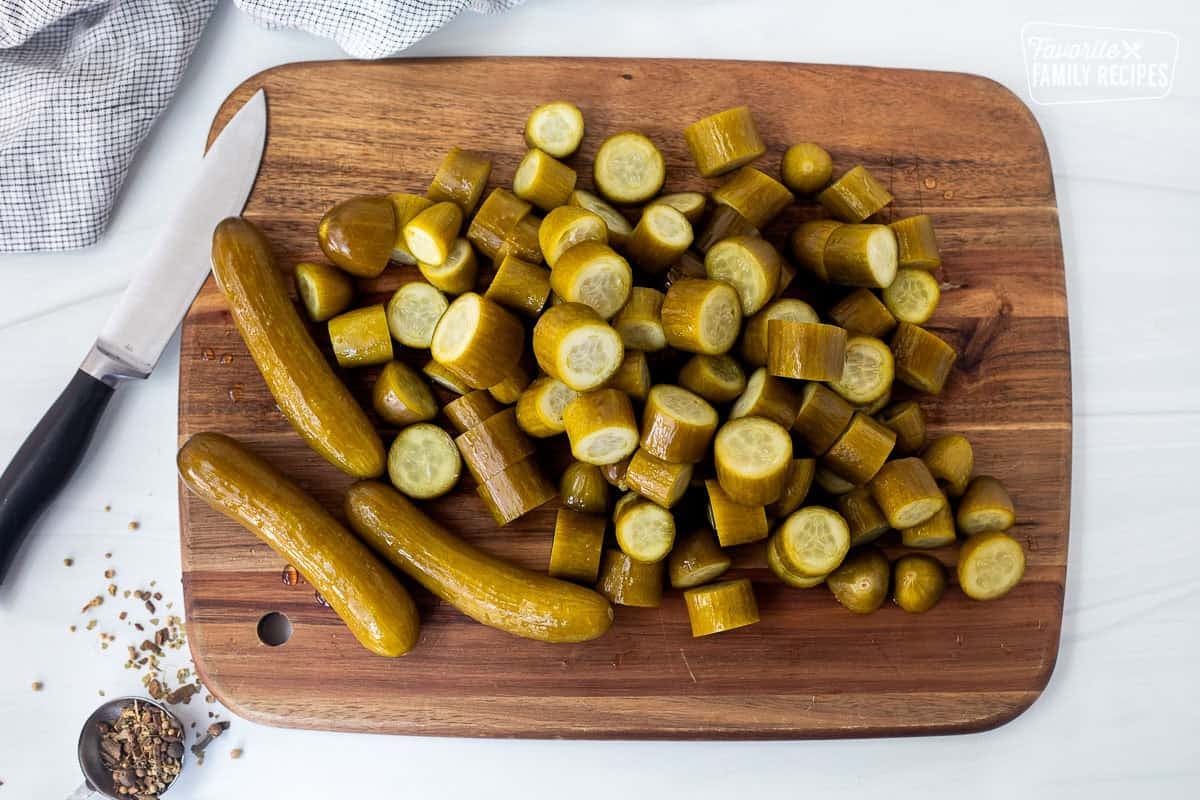 Cut cucumber pieces on a cutting board with a knife.