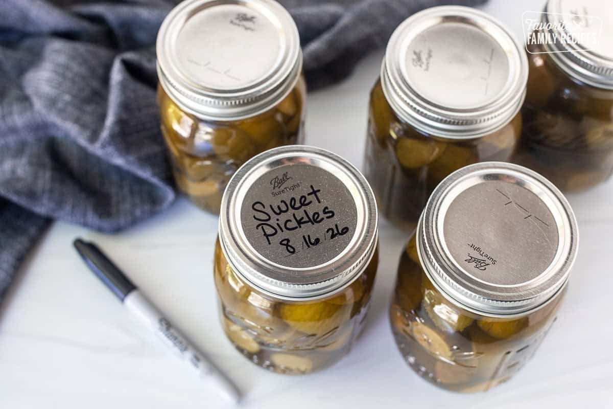 Labeling the tops of the sweet pickle jars with name and date.